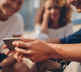 a group of people looking at a mobile phone